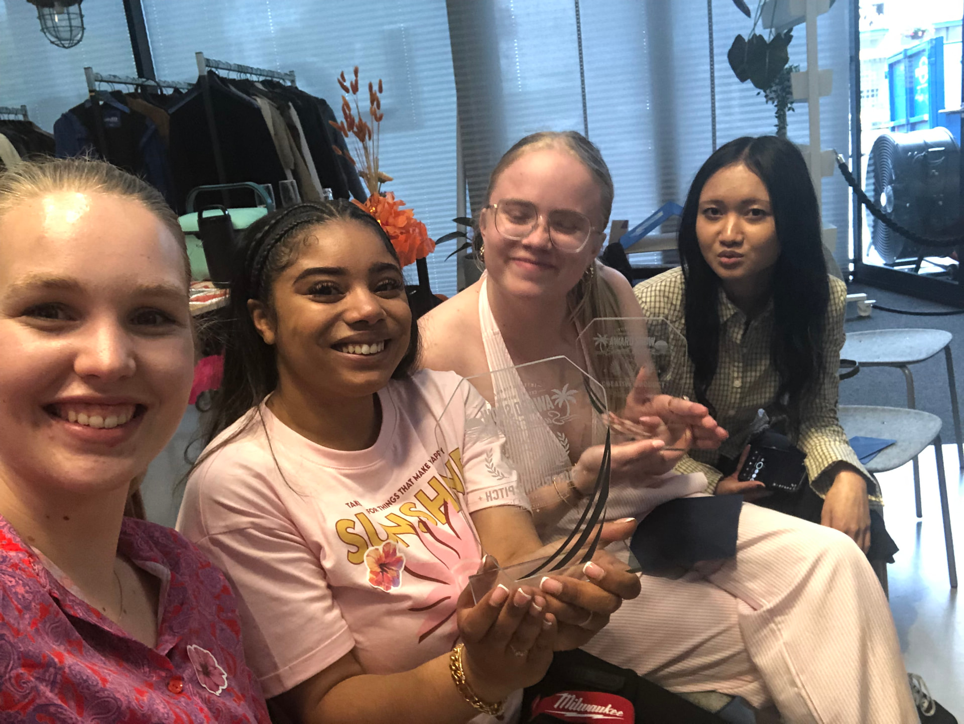 Future Design Studio team taking a candid selfie with two awards